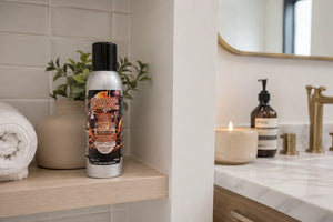 Pumpkin and waffles odor eliminating air freshener on bathroom shelf next to sink and vanity. 