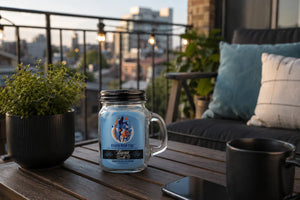 Rager High Tide Beamer Candle sitting on small table on outdoor apartment balcony with city view in background