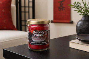 Dragons blood odor exterminating candle sitting on dark coffee table in minimalist Japanese style living room with red and black decor. 